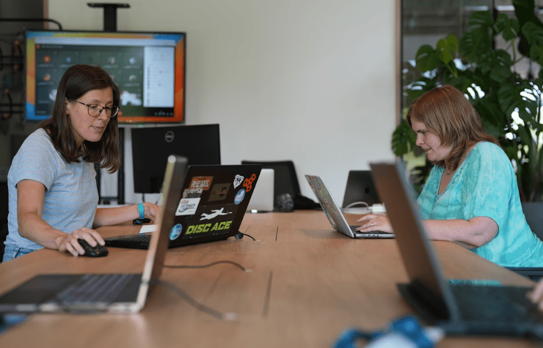 A developer working on both frontend and backend code on dual monitors