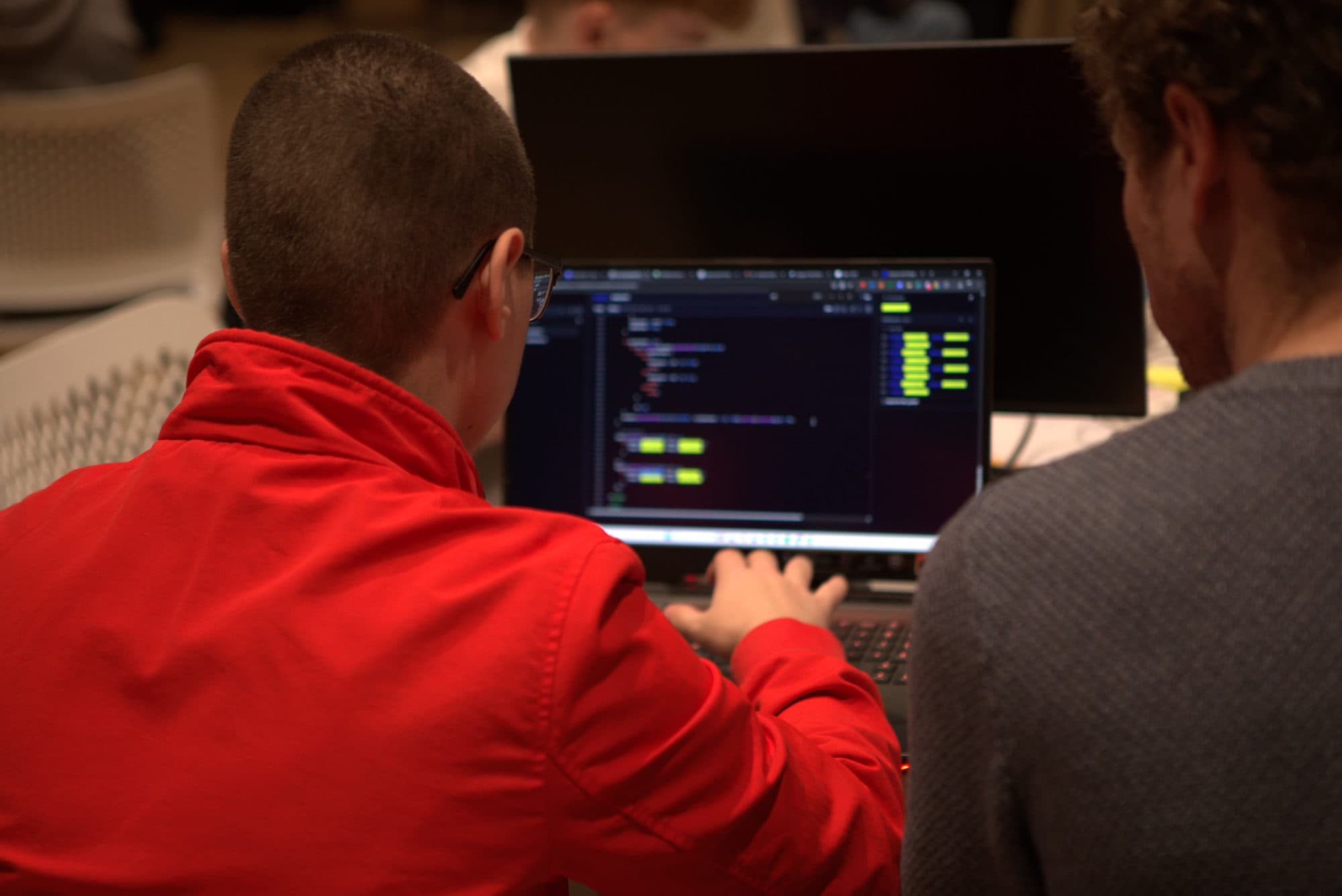 A participant writing code alongside a mentor at HackEd Norwich 2026