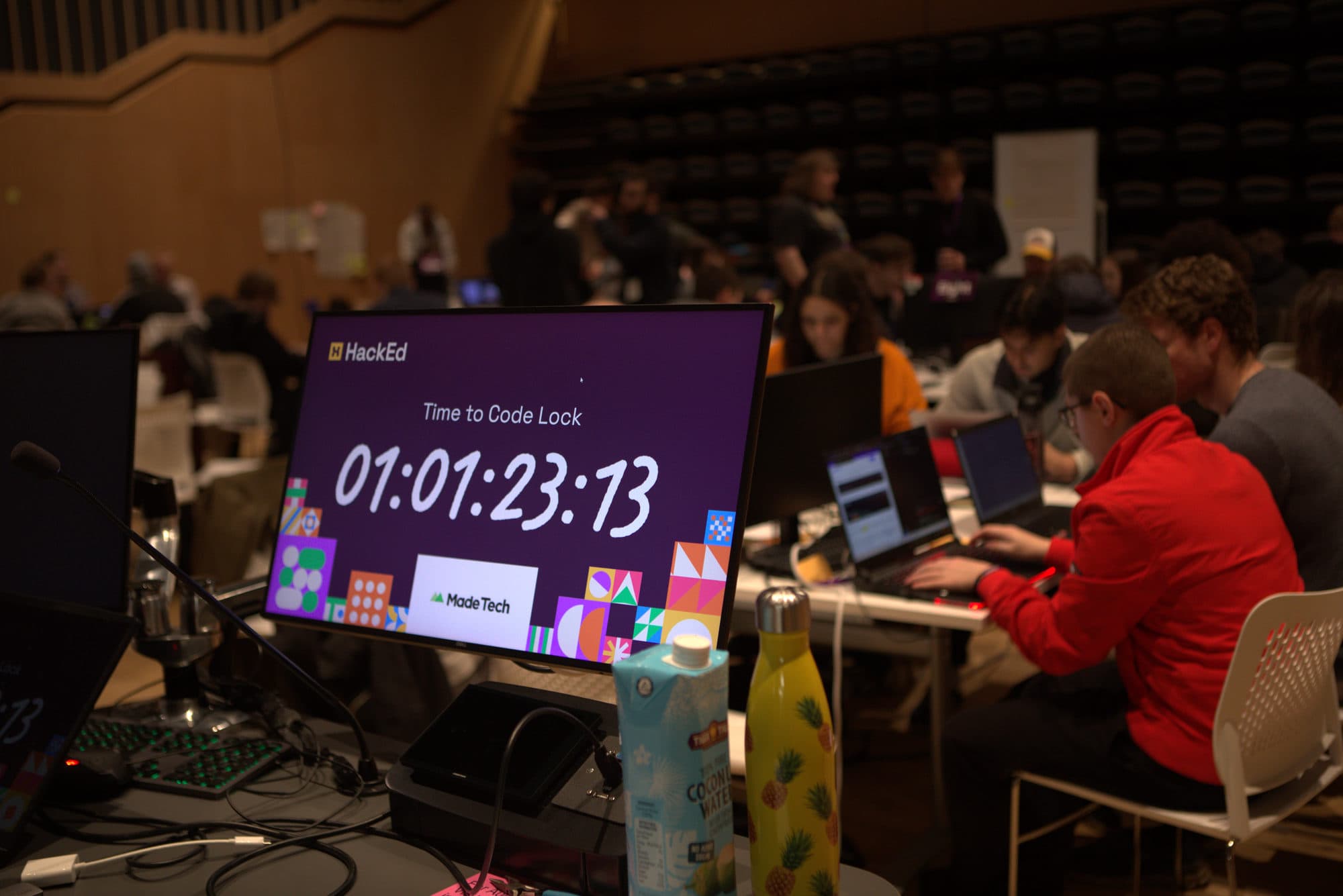 The HackEd countdown clock beside a participant coding at HackEd Norwich 2026