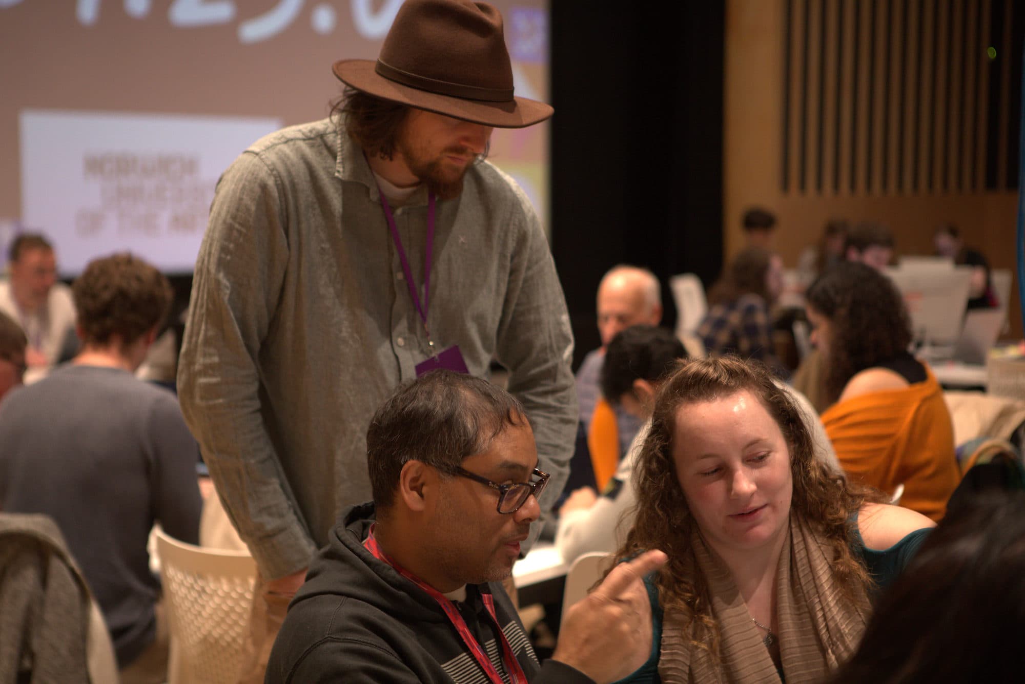 A mentor advising two participants at their table during HackEd Norwich 2026
