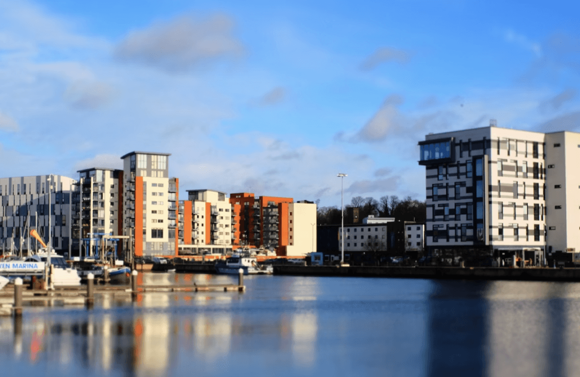 A picture overlooking a river, with high-rise apartments in the distance