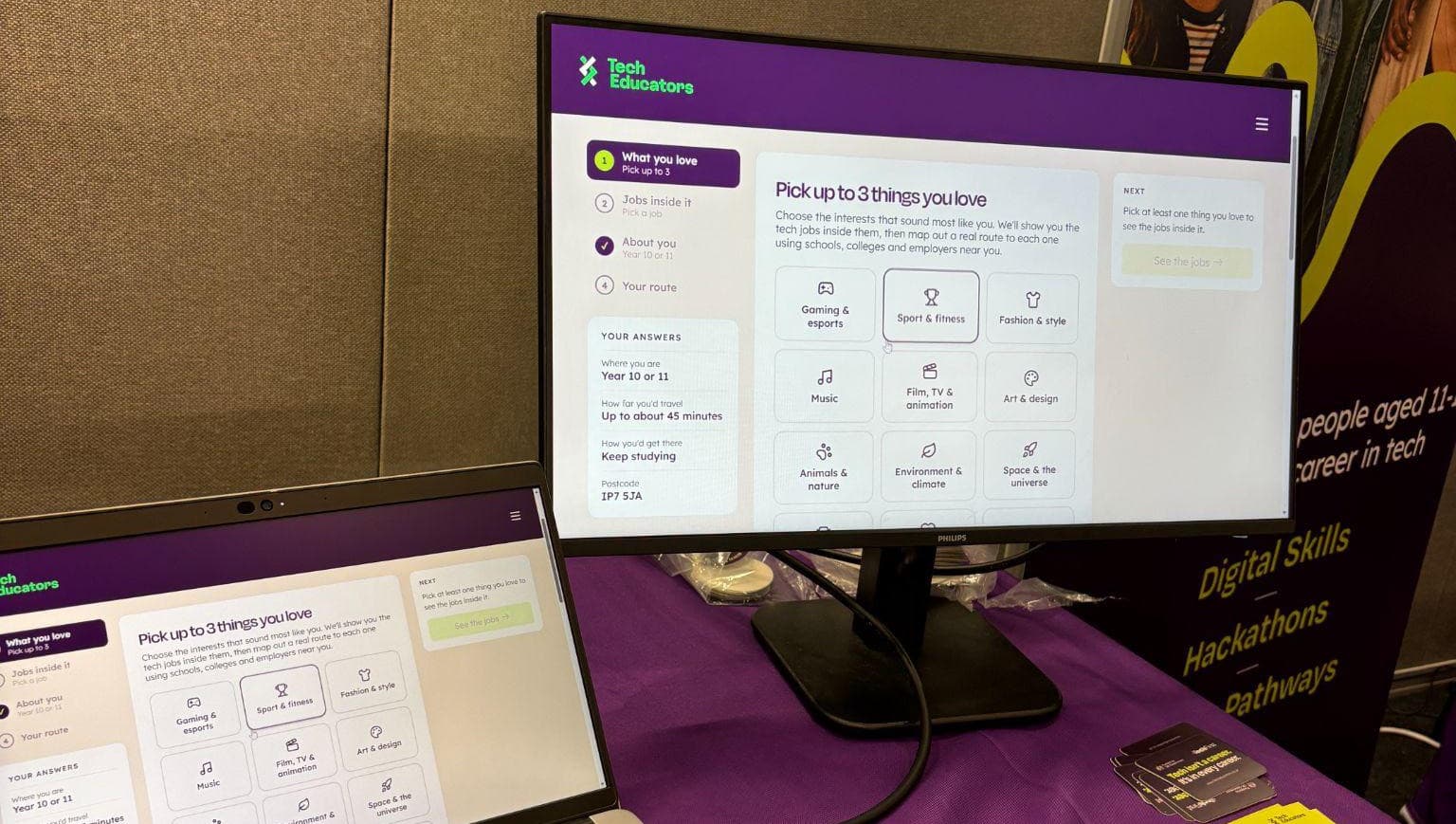 A laptop and a linked monitor on a Tech Educators stand, both showing the Tech Pathways interest picker