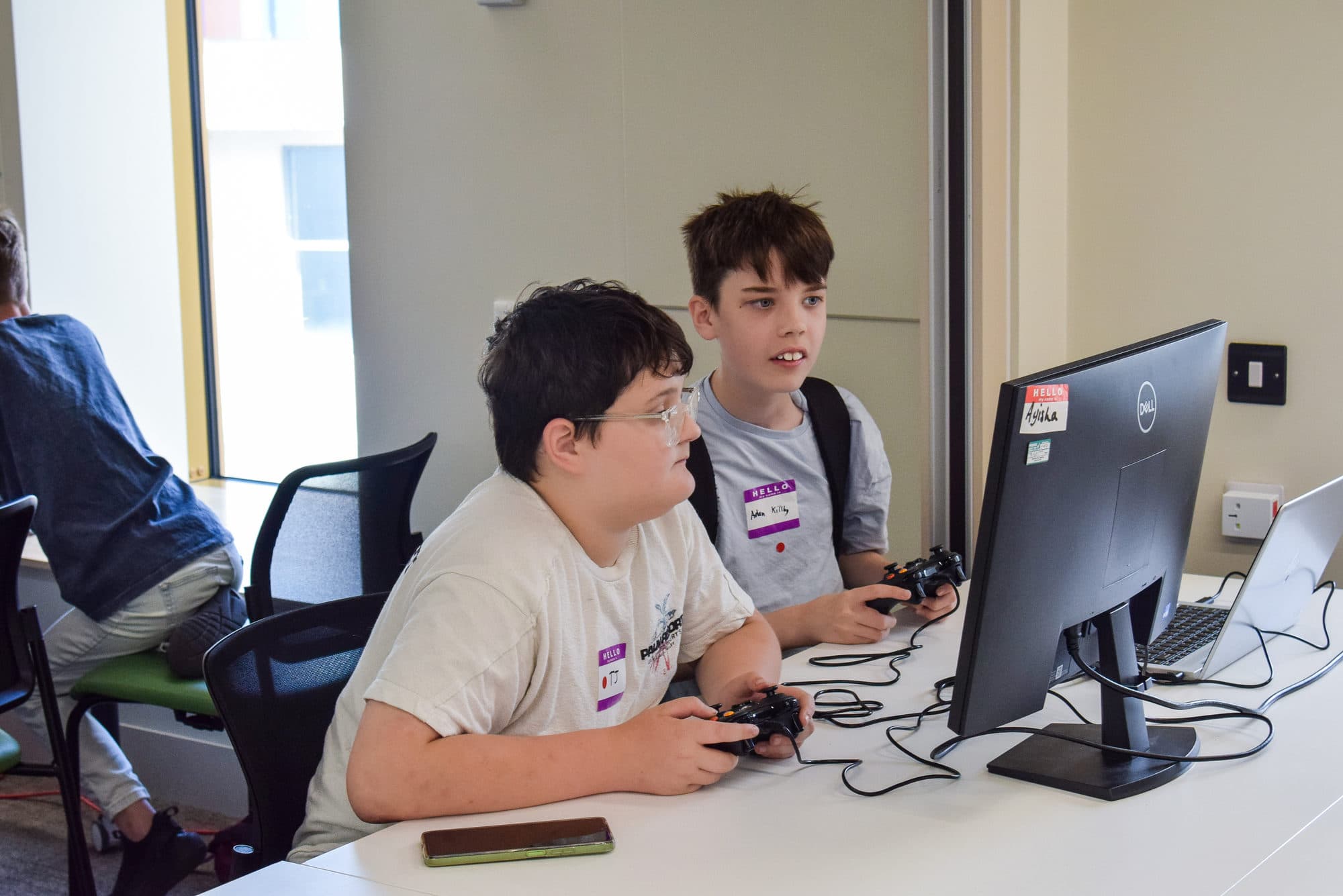 Participants playing together at a monitor during the Gaming Day