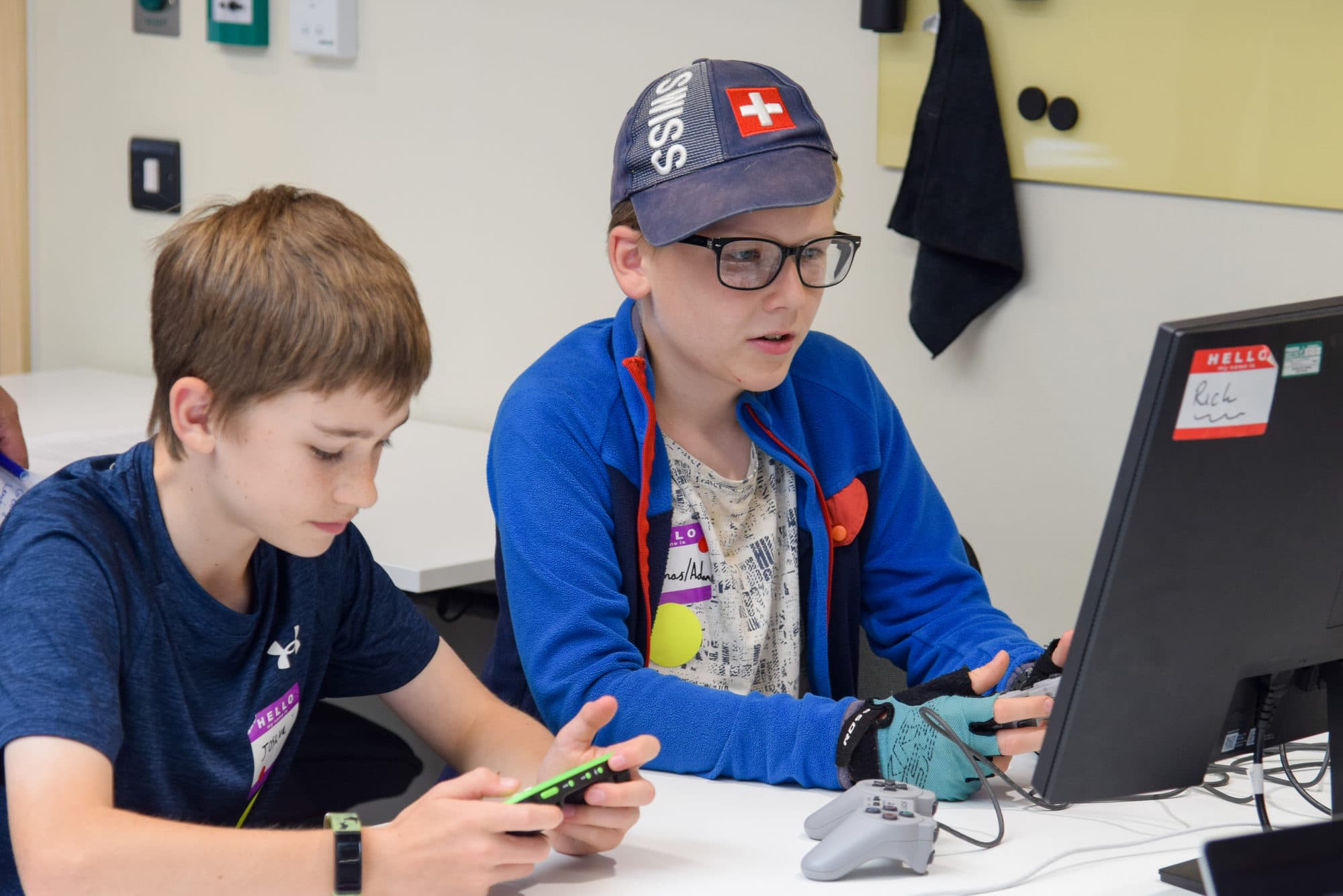 Two participants playing handheld consoles together at the Gaming Day