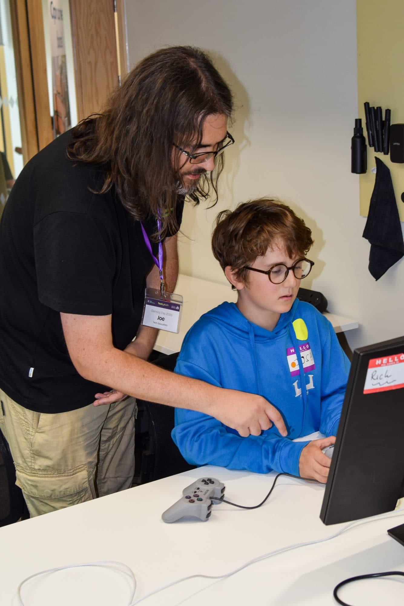 A mentor helping a young participant at the Gaming Day