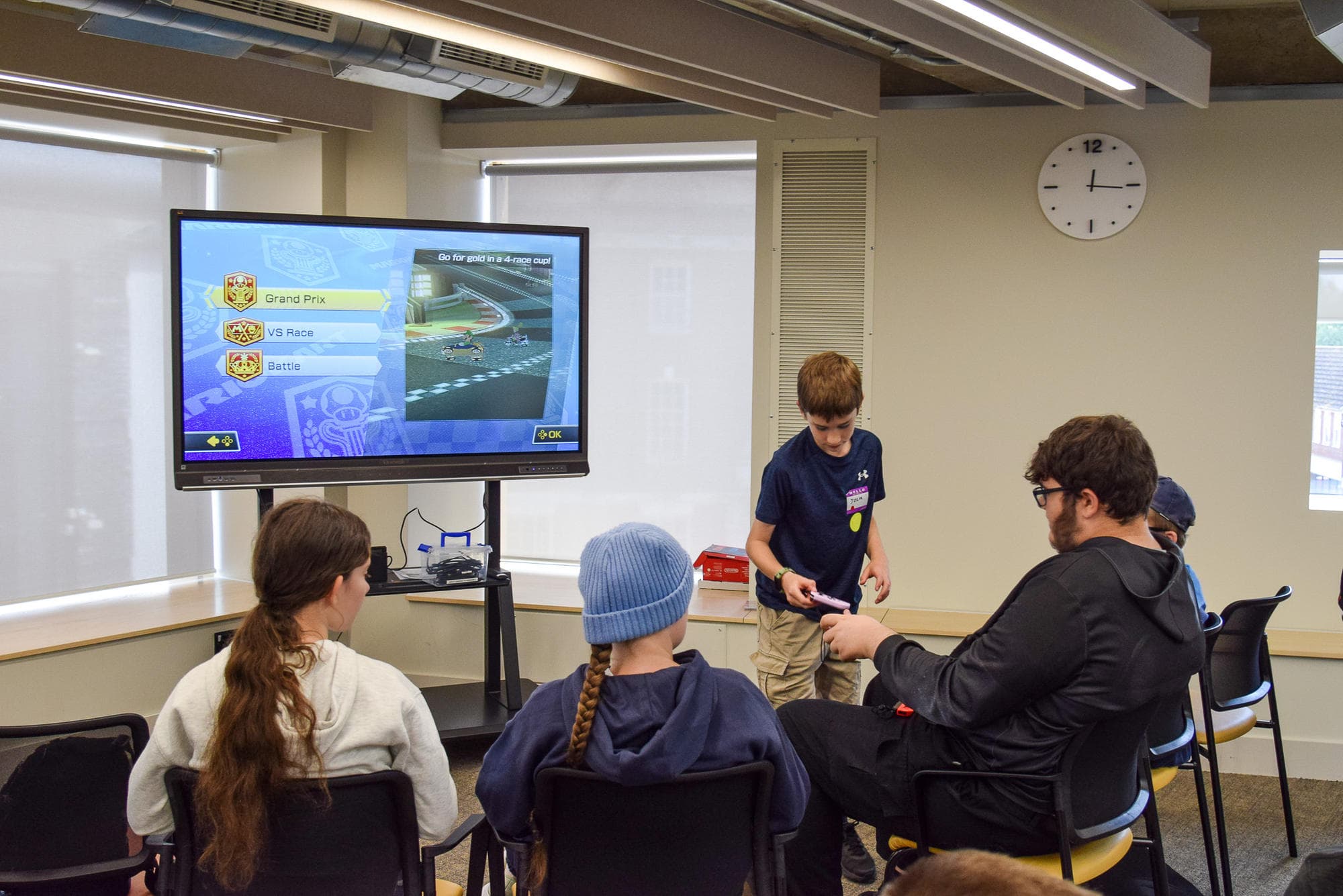 Participants watching a racing tournament on the big screen at the Gaming Day